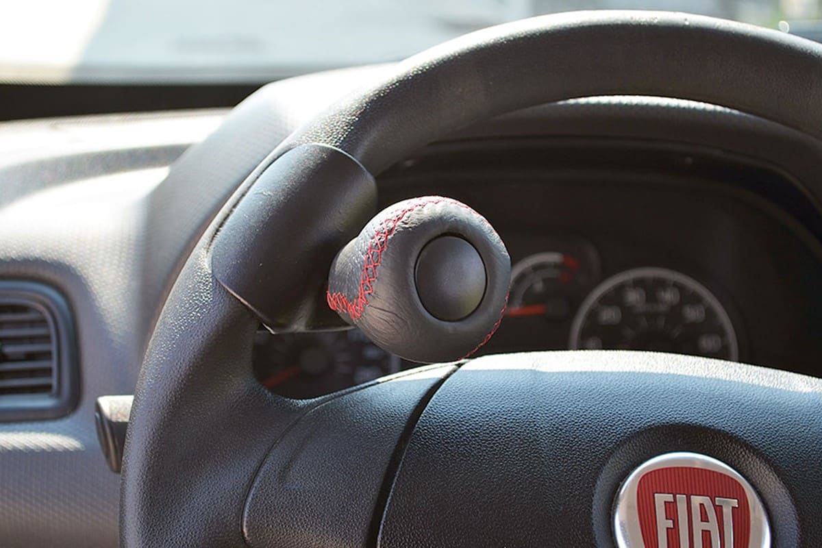 Leather Spinner Knob with Red Stitching on a stewing wheel of a Fiat Vehicle.