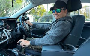 Joel Fernandes in his car with his left hand using the Fadiel Easy Drive