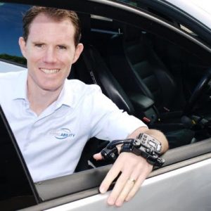 Man in wheelchair leaning on open car door