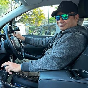 Joel Fernandes in his car with his left hand using the Fadiel Easy Drive